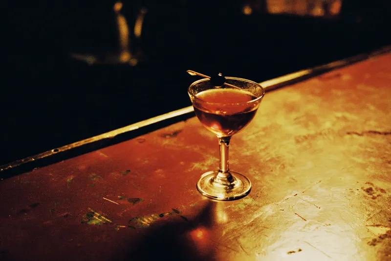 Shaoxing Manhattan: deep amber cocktail with a cherry in a coupe glass