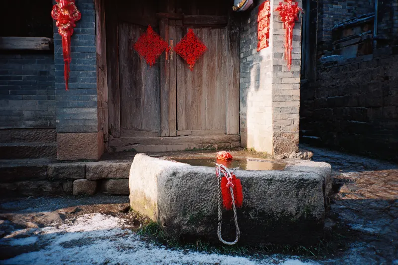 A red silk bag hanging over a stone well on New Year's morning
