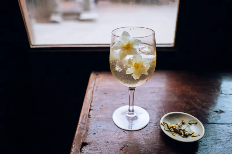 Jasmine White Spritz: pale white wine spritz with jasmine flowers in a wine glass